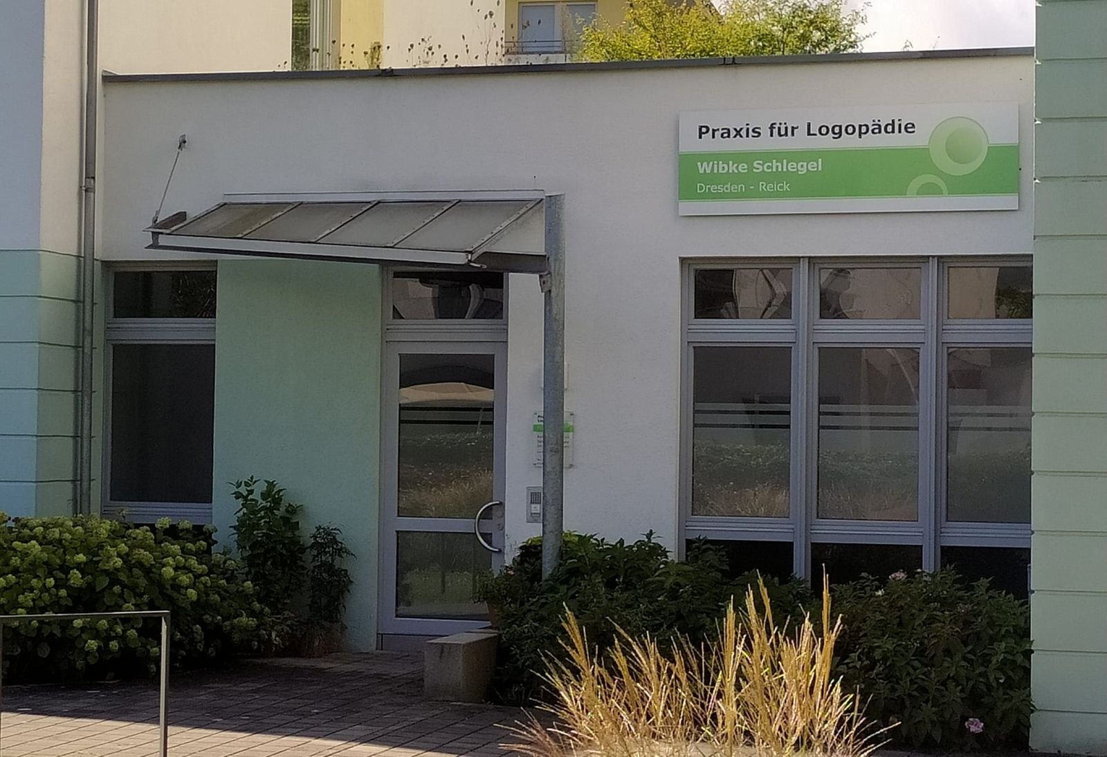 Eingang der Praxis für Logopädie mit Praxisschild über der Tür